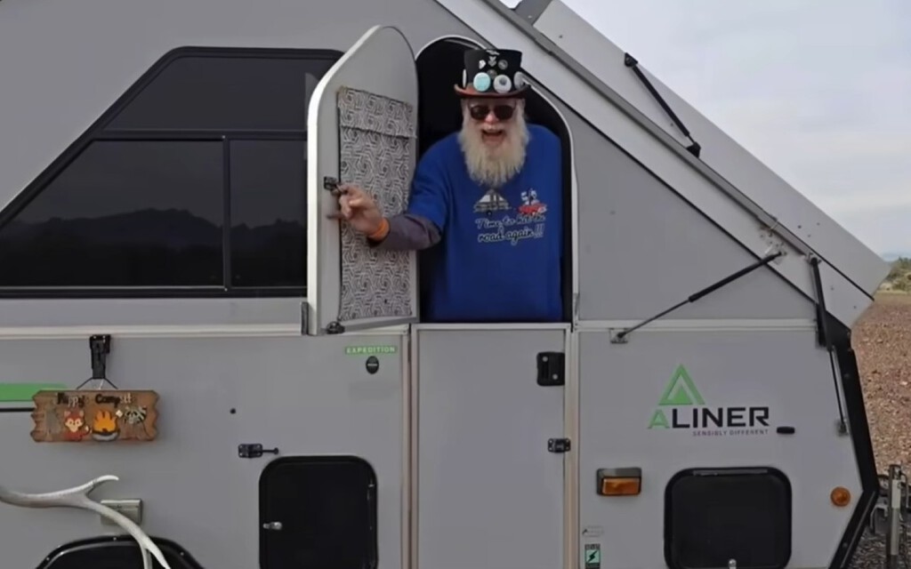 Jubilado conduciendo su camper en un paisaje rural estadounidense.