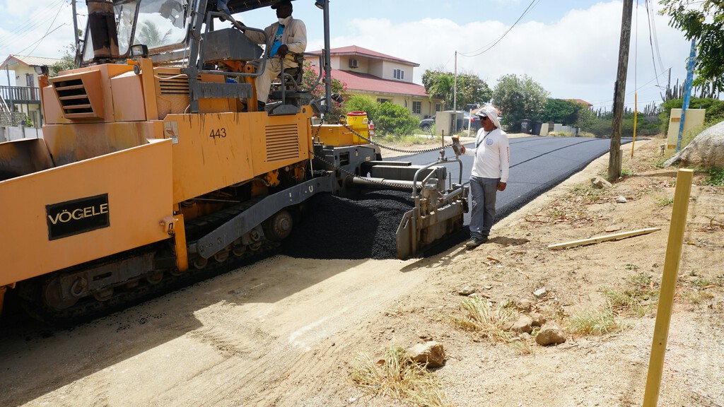 Vehículos circulando sobre pavimento reflectante en una ciudad marroquí