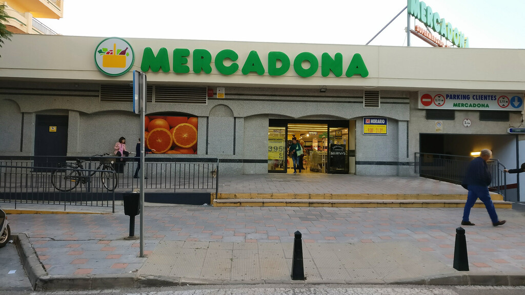 Empleado de Mercadona en una oficina con documentos y ordenador en un entorno laboral