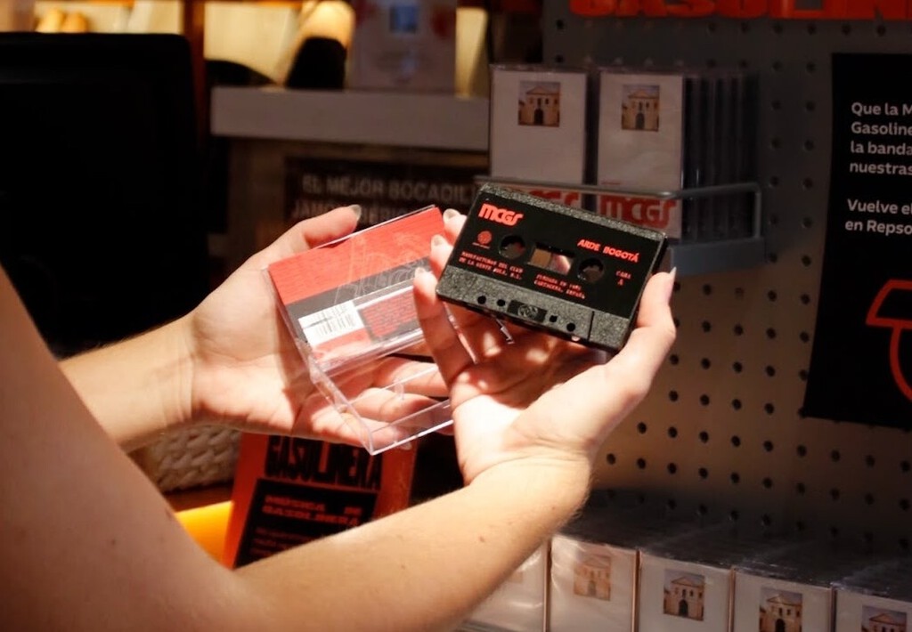 Personas en una gasolinera Repsol comprando cassettes vintage en 2026
