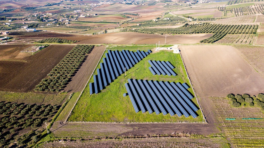 Paneles solares elevados sobre cultivos en un campo agrícola español