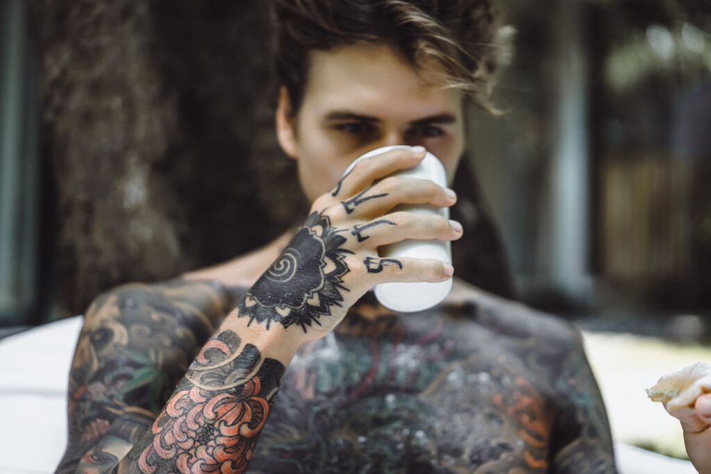 Persona mostrando tatuaje invisible que se revela bajo luz ultravioleta en un entorno social